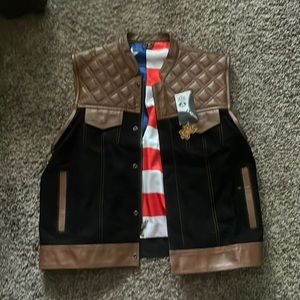 Motorcycle vest. Black denim and brown leather. No brand on it.